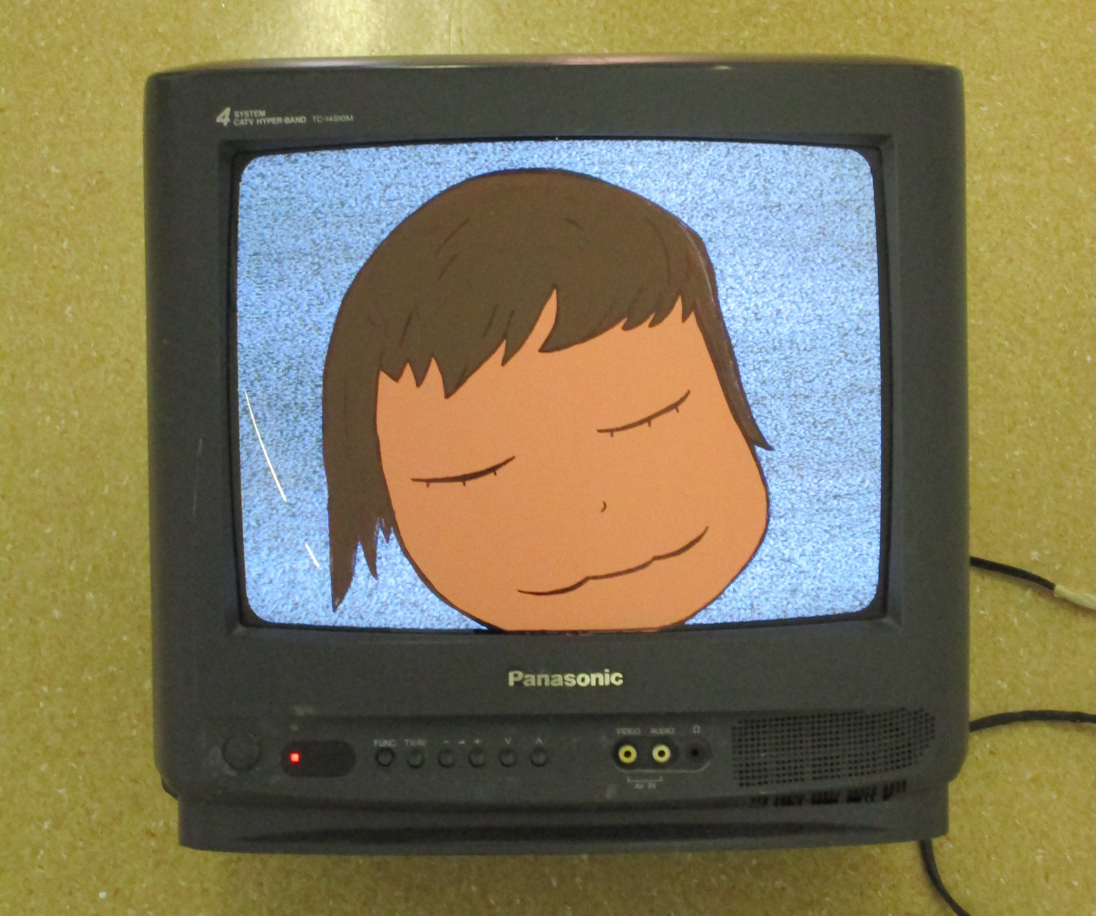 Sleeping cartoon face painted on CRT television.